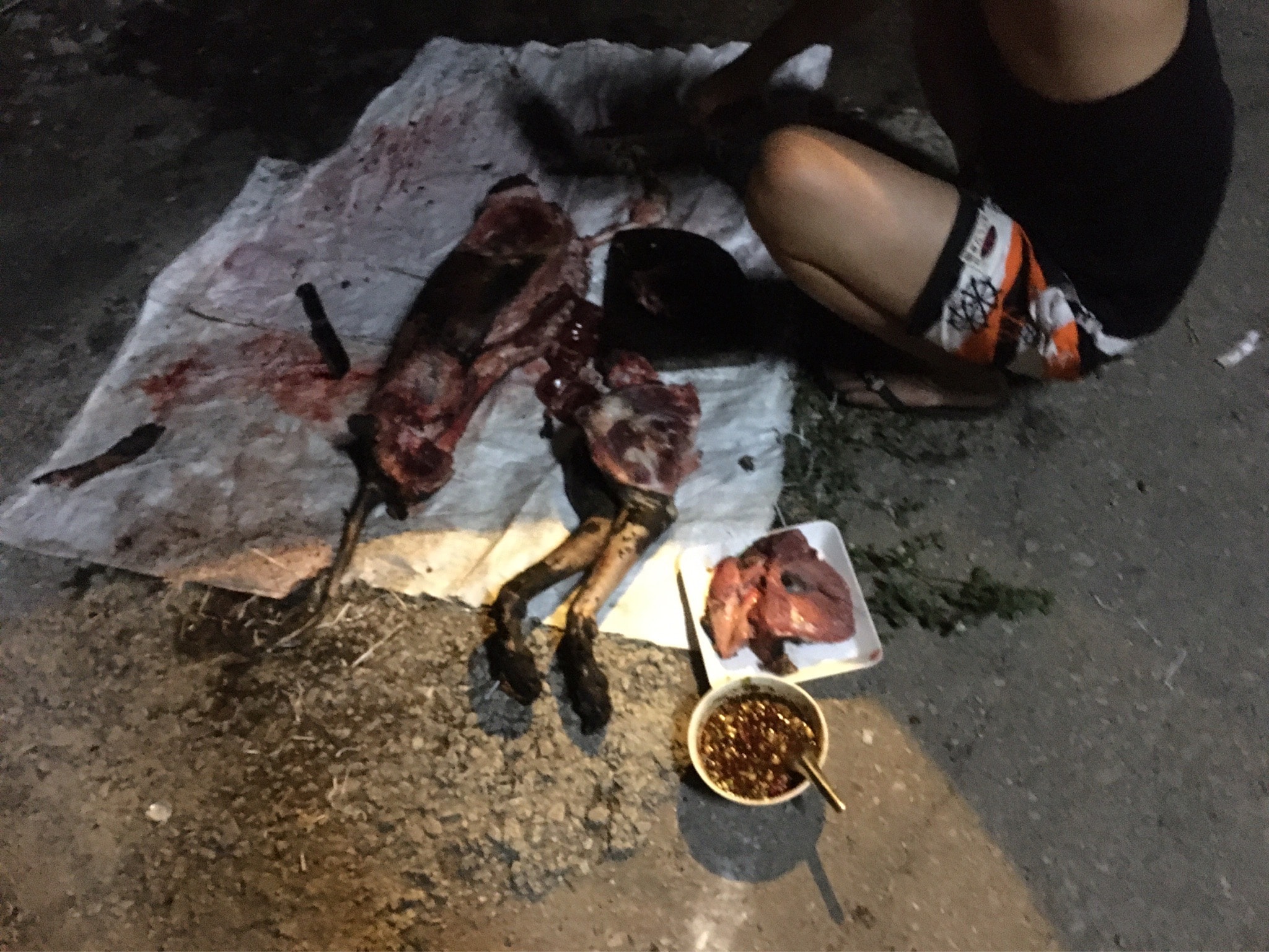 SLAUGHTERING AND GRILLING DOG FOR FOOD. Nakorn Chai Si District, Nakorn Pathom Province
